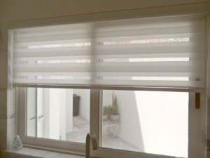 Cortines i Estors, Presa de mesures gratis, Confeccionem i instal·lem Cortines i Estors, Riells i Barres. Varietat en Teixits i Estores Moderns, Estors Enrotllables, Estors Paqueto, Estores Plegables, Cortines Nit i Dia, Cortines Veneciana de fusta, Persianes Venecianes alumini, Cortines Verticals, Cortines Plisades o Panells Japonesos. Protecció Solar exterior, Tendals, Fet a mida per vestir la seva finestra, Automatismes i Motoritzacions. Servei de presa de mesures i instal·lació de cortines i estores a Andorra. El mejor diseño de cortinas es a menudo el último toque de decoración de interiores por el que nos decidimos. En general, vienen después de la elección de los muebles, el color de las paredes y el resto de los complementos. Pero, no por ello, las cortinas son menos importantes. Las cortinas en una habitación son comparables a los zapatos o el peinado en el estilismo final de una persona. Siempre destacó la importancia de las cortinas en el diseño, las cortinas le dan la terminación a la decoración de interiores y hacen las habitaciones más acogedoras. En el caso del diseño moderno, donde todos los elementos son tan estructurados, se hace absolutamente necesario tener cortinas, ya que con éstas, logras el aspecto hogareño que necesitas. Veamos a continuación algunas ideas para la decoración con cortinas de diseño moderno. El material de la cortina depende de dos factores fundamentales, el efecto que busques causar con las cortinas y la cantidad de luz que quieras dejar pasar a través de la misma. En el caso del diseño moderno, el efecto que se busca causar con las cortinas, es un efecto sin demasiado drama, más bien algo puro, pero acogedor. Por lo que sólo deberás concentrarte en la cantidad de luz que quieras dejar pasar a través de la cortina. Si quieres eliminar la luz, tienes la opción de elegir cortinas black out, que evitarán que pase la luz del sol. Por otro lado, en caso de que quieras dejar pasar luz moderada a través de las cortinas puedes elegir cortinas de gasa. Este tipo de tela para cortinas vienen en distintos grosores, ideales para cambiar la intensidad de luz que entra por tu ventana. si bien el diseño moderno presenta una paleta tradicionalmente monocromática, es común insertar colores vibrantes dentro de la decoración moderna. Una de las maneras de insertar color es, justamente, a través de las cortinas. Para decorar con cortinas en una habitación de estilo moderno, recomiendo que si eliges un color, luego lo equilibres, colocando el mismo color en la zona opuesta de la habitación. Coloca cojines, o pequeños adornos que tengan el mismo color que la cortina o una alfombra en el centro de la habitación. Pero no satures la habitación llenándola de éste color en particular, más bien, debes colocar pequeños detalles para equilibrar. Dependiendo de la habitación de la casa que estés decorando, puedes elegir entre diferentes tipos de cortinas. Las cortinas tipo venecianas se dan muy bien con la decoración de interiores moderna. Sin embargo, no son apropiadas para los dormitorios o las salas familiares, pues no brindan el efecto acogedor que se busca al colocar cortinas en dichas habitaciones. No obstante, puedes colocarlas en la oficina o la cocina, donde logran adaptarse muy bien al diseño. Para el resto de las habitaciones, recomiendo que coloques cortinas clásicas de tela, generarán el equilibrio necesario entre lo moderno y lo acogedor del que hablaba al comienzo. Al elegir el material que usarás para tus cortinas de diseño moderno, no olvides que cuanto más grueso sea el material más resistente será a los lavados. Y al momento de decorar la casa, no dejes de tener en cuenta nuestras claves para colocar cortinas. ¿Qué te parece la idea de decorar con este tipo de cortinas?